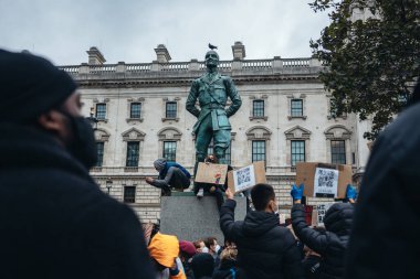 Londra / İngiltere - 06 / 06 / 2020: Siyahi Yaşamı Önemlidir protestosu koronavirüs salgını sırasında. Anıtın üzerinde oturan protestocular