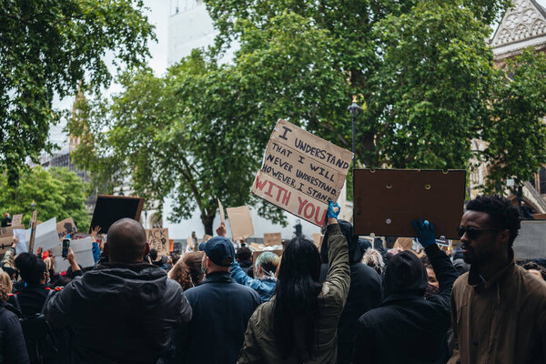 Лондон / Великобритания - 06 / 06 / 2020: Black Lives Matter protest during lockdown coronavirus pandemic. Тысячи протестующих маршируют с табличками, плакатами на Вестминстерской площади, зданиях парламента
