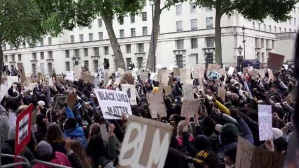 ロンドン イギリス 2020年6月6日 ブラックライブスマターがコロナウイルスの大流行に抗議 何千人もの抗議者が署名を持って行進しましたウェストミンスター広場の旗議会議事堂 — ストック動画