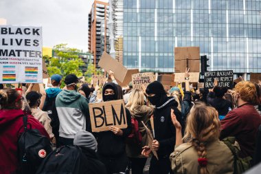 London / UK - 06 / 07 / 2020: Black Lives Matter protestosu koronavirüs salgını sırasında gerçekleşti. ABD büyükelçiliğinde pankartlarla slogan atan protestocu