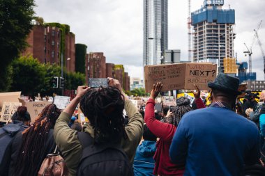 London / UK - 06 / 07 / 2020: Black Lives Matter protestosu koronavirüs salgını sırasında gerçekleşti. ABD büyükelçiliğinde pankartlarla slogan atan protestocu