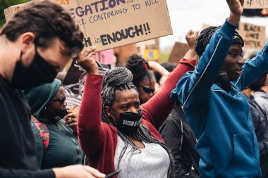 London / UK - 06 / 07 / 2020: Black Lives Matter protestosu koronavirüs salgını sırasında gerçekleşti. ABD büyükelçiliğinde pankartlarla slogan atan protestocu