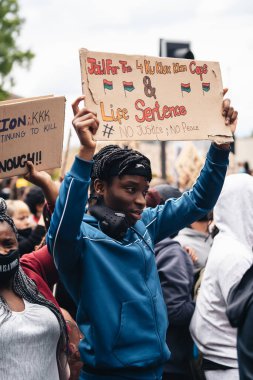 London / UK - 06 / 07 / 2020: Black Lives Matter protestosu koronavirüs salgını sırasında gerçekleşti. ABD büyükelçiliğinde pankartlarla slogan atan protestocu