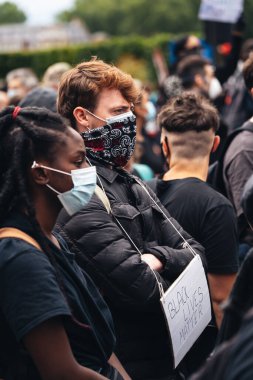 London / UK - 06 / 07 / 2020: Black Lives Matter protestosu koronavirüs salgını sırasında gerçekleşti. ABD büyükelçiliğinde pankartlarla slogan atan protestocu