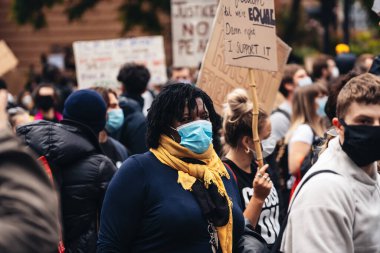 London / UK - 06 / 07 / 2020: Black Lives Matter protestosu koronavirüs salgını sırasında gerçekleşti. ABD büyükelçiliğinde pankartlarla slogan atan protestocu