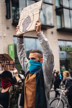 London / UK - 06 / 07 / 2020: Black Lives Matter protestosu koronavirüs salgını sırasında gerçekleşti. ABD büyükelçiliğinde pankartlarla slogan atan protestocu