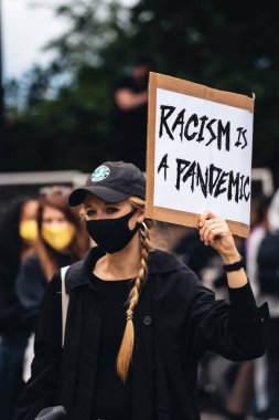 London / UK - 06 / 07 / 2020: Black Lives Matter protestosu koronavirüs salgını sırasında gerçekleşti. ABD büyükelçiliğinde pankartlarla slogan atan protestocu