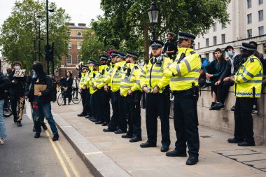 London / UK - 06 / 07 / 2020: Black Lives Matter protestosu koronavirüs salgını sırasında gerçekleşti. Downing Caddesi 'nde polis memurları.