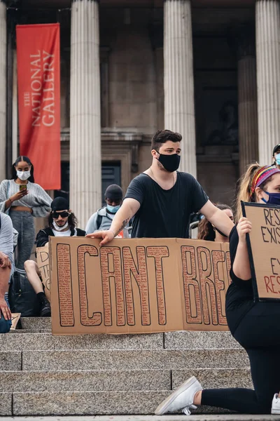 Londra / İngiltere - 06 / 13 / 2020: Siyahi Yaşamı Önemlidir protestosu koronavirüs salgını sırasında. Genç beyaz çocuk Trafalgar Meydanı 'nda diz çöküyor.