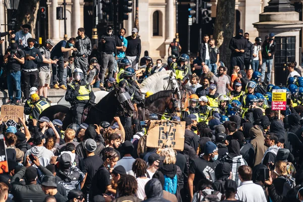 Londra / İngiltere - 06 / 13 / 2020: Siyahi Yaşamı Önemlidir protestosu koronavirüs salgını sırasında. Trafalgar Meydanı 'nda yüzlerce insan şişe fırlatıyor ve polis memurlarını taciz ediyor.