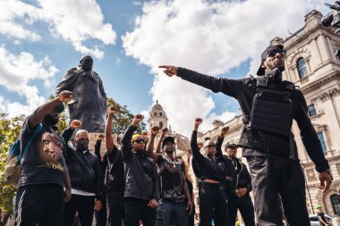Londra / İngiltere - 06 / 20 / 2020: Siyahi Yaşamlar Grubu Sör Winston Churchill Anıtı önündeki protestocular, yumruklarını havada tutan video kliplerini kaydediyor