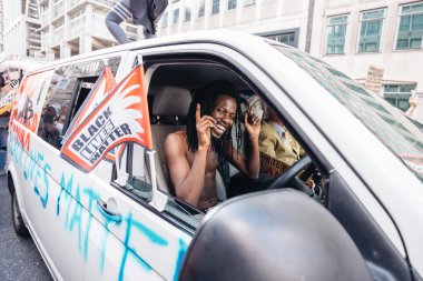 Londra / İngiltere - 06 / 20 / 2020: Siyahi Yaşamlar 'ın büyük kalabalığı önünde direksiyon başında dans eden minibüs sürücüsü, protestocular Parliament Square, Westminster' a gidiyor, ellerinde sloganlar ve afişler var
