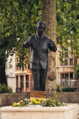Londra / İngiltere - 06 / 27 / 2020: Nelson Mandella heykelindeki plackardsn pankartları ve çiçekler Siyah Yaşamlar Önemli Protesto / 2020: