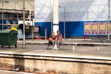 Londra / İngiltere - 06 / 27 / 2020: Coronavirus salgını sırasında Waterloo istasyonunda tren bekleyen erkek ve kadın çift