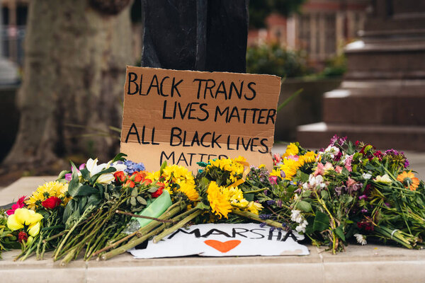 London / UK - 06/27/2020: plackardsn banners and flowers at Nelson Mandella statue At Black Lives Matter Protest/2020: