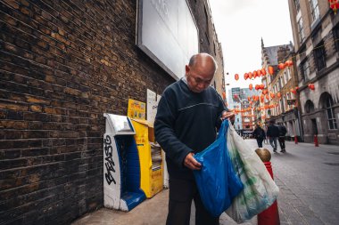 Londra / İngiltere - 07 / 11 / 2020: Coronavirus tecridi sonrasında Soho 'da kalabalık caddelerde yürüyen yaşlı Asyalı beyefendi