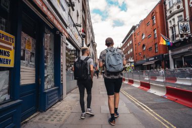 Londra / İngiltere - 07 / 11 / 2020: Coronavirus tecridi sonrasında Soho sokaklarında gezen sırt çantalı iki adam