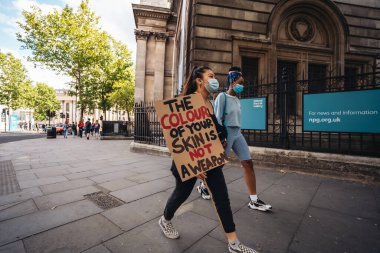 Londra / İngiltere - 07 / 11 / 2020: Coronavirus tecridi sonrasında Soho 'nun işlek caddelerinde yürüyen BLM sancaklı genç bayanlar