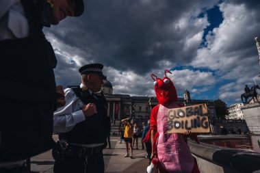 Londra / İngiltere - 07 / 11 / 2020: Londra 'daki Trafalgar Meydanı' nda Hayvan Hakları Grubu 'nun kaynaklarını kırmızıya çevirmesi sonrasında protestocularla sohbet eden polis memurları
