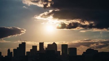 Londra / İngiltere - 07 / 11 / 2020: Canary Wharf Business alanındaki gökdelenlerin günbatımı saatlerinde bulutlu renkli zamanlaması