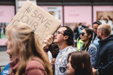 Londra / İngiltere - 2020.09.05: Çocuk Kaçakçılığını Koruma Eylemi 'ne pankart ve pankartla bağıran kişiler.