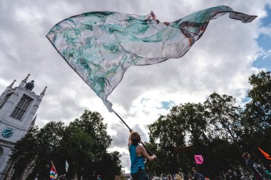 Londra / İngiltere - 2020.09.05: Meclis meydanında Soyu Tükenme İsyanı 'nda dev bir bayrak sallayan genç adam