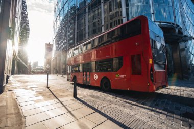 Londra / İngiltere - 2020.07.18: Liverpool Street istasyonunun yanındaki kırmızı çift katlı otobüs gün batımında sıcak bir yaz akşamı