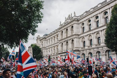 Londra, Birleşik Krallık 2025.09.13 Londra şehir merkezindeki tarihi bir hükümet binasının önünde düzenlenen Özgür Konuşma sırasında büyük bir kalabalık Union Jack ve St. Georges Cross bayraklarını sallıyor.. 