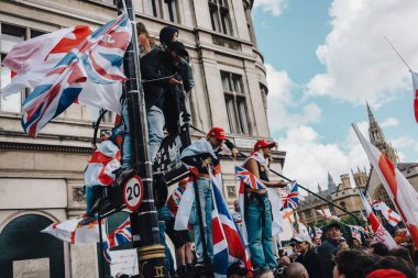 Londra, Birleşik Krallık 2025.09.13 Göstericiler Londra şehir merkezinde düzenlenen Özgür Konuşma Protestosu sırasında Westminster yakınlarındaki tabela ve sokak lambalarına tırmanırken Union Jack ve St. Georges Cross bayraklarını sallıyorlar.. 