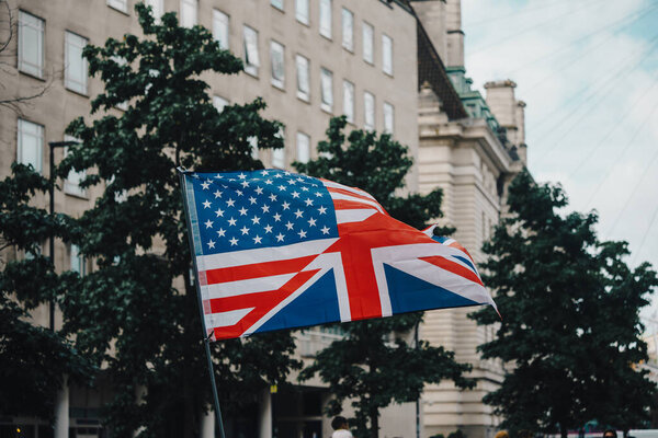 Лондон, Великобритания 2025.09.13 Гибридный флаг, сочетающий дизайн US Stars and Stripes с британским Union Jack, виден во время акции протеста за свободу слова в центре Лондона. 