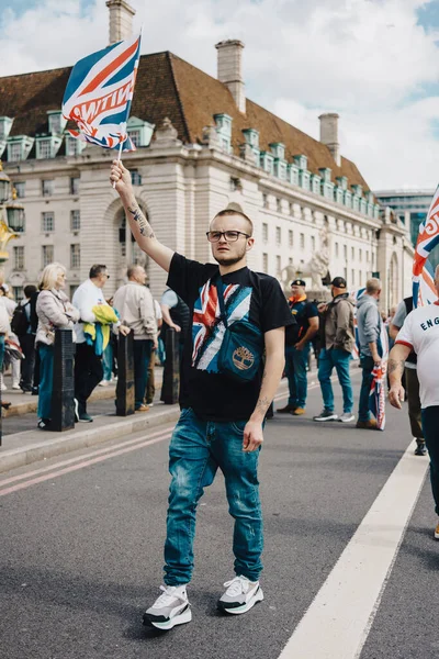 London, UK 2025.09.13 Union Jack tişörtü giyen genç Londra sokaklarında düzenlenen Özgür Konuşma protestosu sırasında bayrak kaldırdı. 