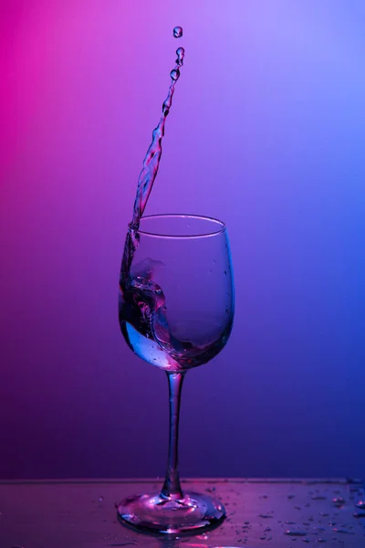 Water splashing out of a wine glass. — Stock Photo, Image