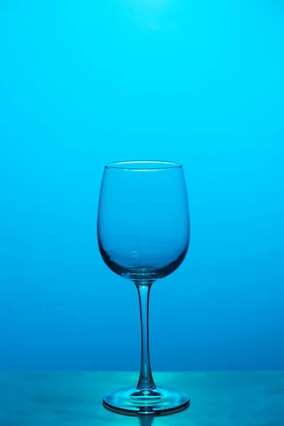 Leeg glas wijn op blauwe achtergrond — Stockfoto