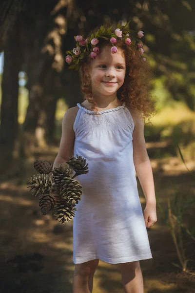 Menina de cabelo vermelho andando em bosques com flores . — Fotografia de Stock