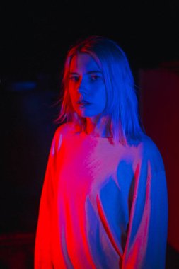 Sarışın kadın neon ışığa dönüşüyor. Akşamları gece kulübü hayatı.