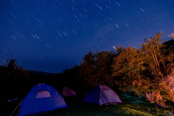 Night camping into the mountain, long exposure stars on the sky photo.