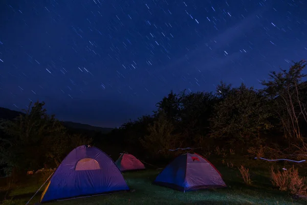 Night camping into the mountain, long exposure stars on the sky photo.