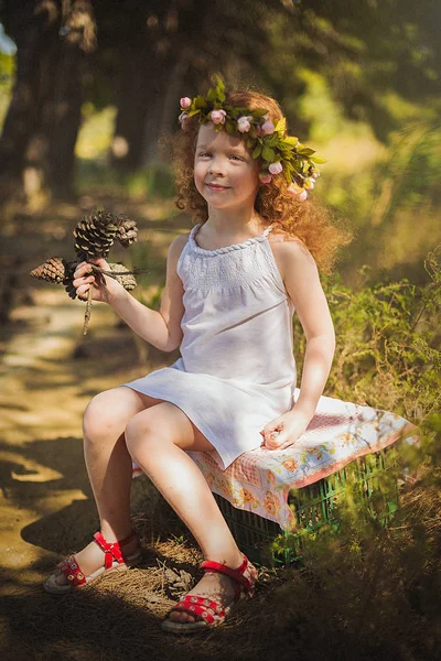 Rood haar baby meisje wandelen in het bos met bloemen. — Stockfoto