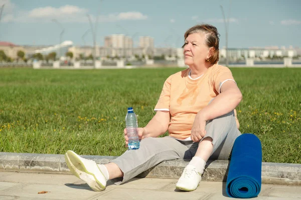 Pensionista mujer descansando después de la formación en el parque. — Foto de Stock