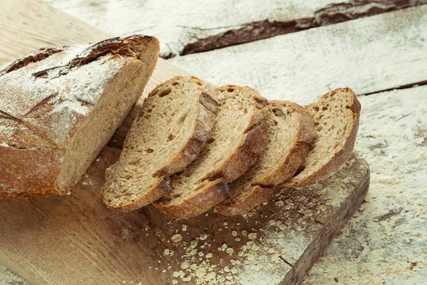 Sliced homemade gluten free bread on cutting board.