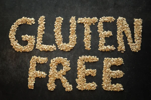 Gluten free word written with cereals on dark background.