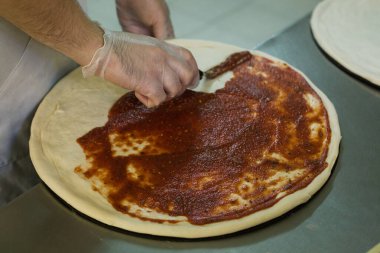 Şef pizzacı mutfağında pizza pişiriyor..