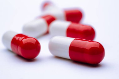 Beyaz arka planda kapsül hapları, bağımlılığa yol açabilecek ilaçların yakın çekimi. Sigorta tabletleri reçeteyle verilir.