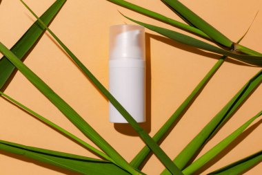 Turuncu arka planda beyaz cilt bakım tüpü, reklam konsepti. Marka için yeri, metin için boş alanı olan vücut derisi arıtma kabı.