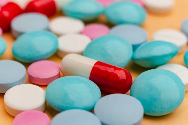 Turuncu arka plandaki hapları kapat, ağrı kesici bağımlılığı kavramını. Bir sürü hap, aşırı doz. Antibiyotik tedavisi.