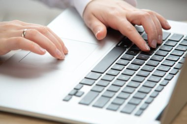 Dokunmatik ped kullanan bir kadın el bilgisayarı üzerinde çalışıyor. Evde karantinada çalışıyor. Ofiste çalışan iş kadını..
