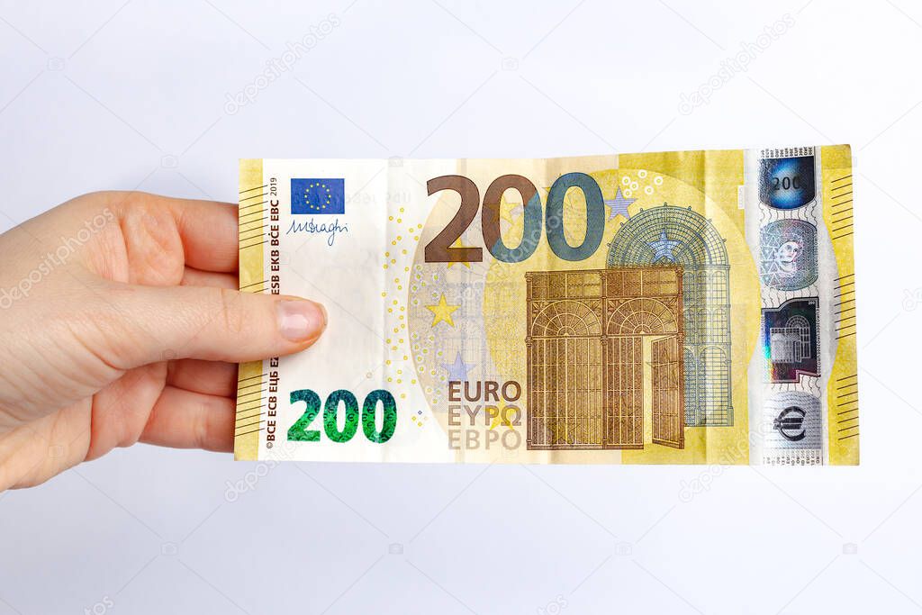 Two hundred euro banknote in woman's hand. Concept of paying taxes in the end of a year. Crisis after coronavirus quarantine.