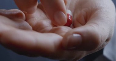 Kadın ellerine kapsül hapları verip hapları içmelerini sağla. Baş ağrısı için ağrı kesici..