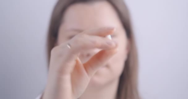Frau hält Kapselpille in der Hand und trinkt Wasser. — Stockvideo
