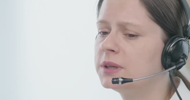 Mujer con auriculares hablando con un cliente con cara triste para resolver problemas . — Vídeos de Stock